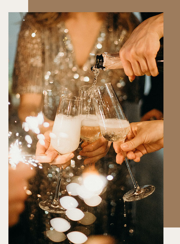 champagne glasses clinking with sparklers around them